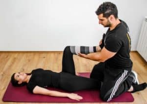 Man and woman doing stretching exercises on a yoga mat.